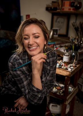 Girl laughing holding paint brush